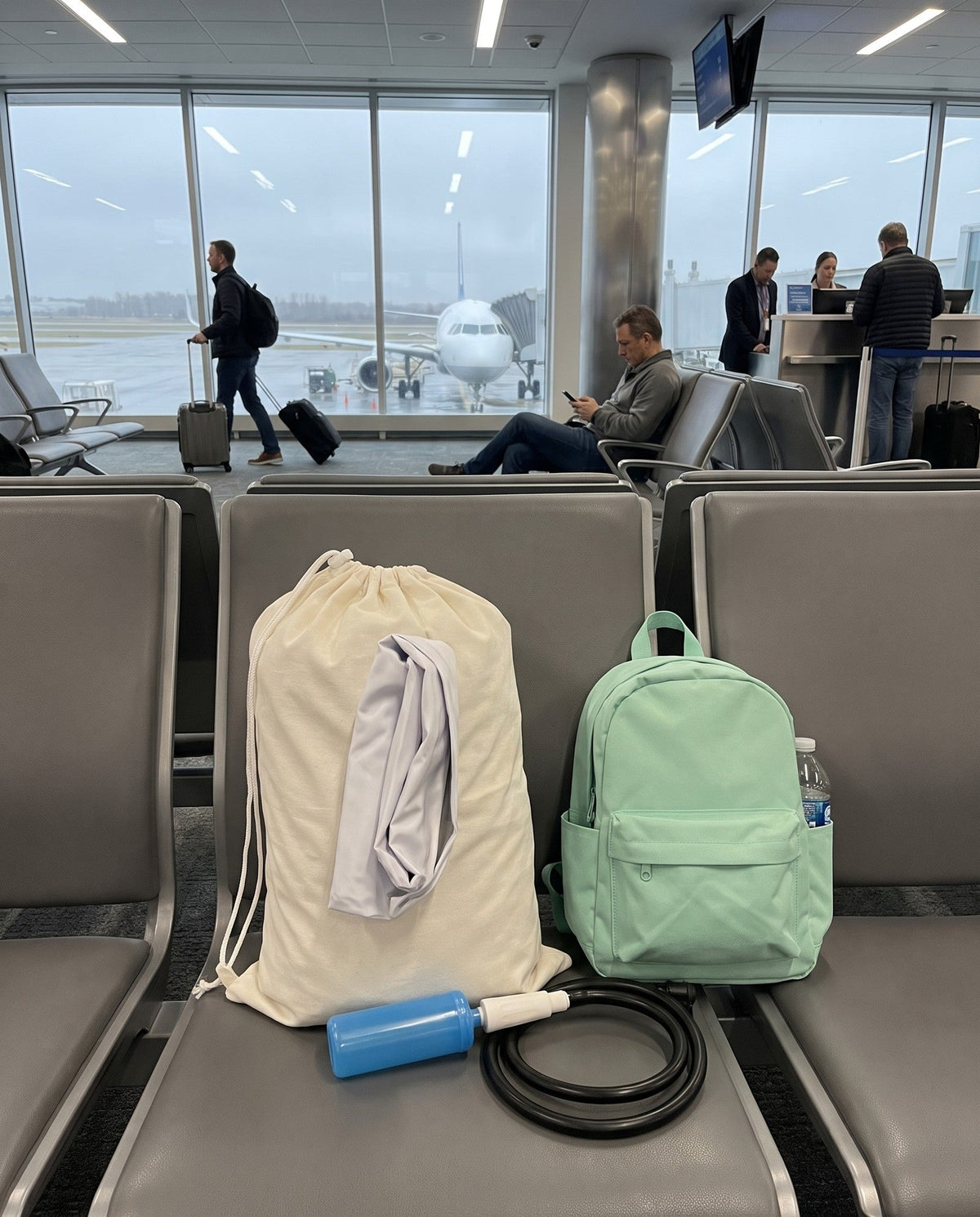 Travel Nest Kids Bed deflated and packed in its white drawstring carry bag with the hand pump